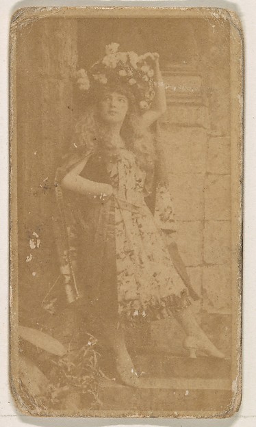 Actress wearing large floral piece in hair, from the Actresses series (N245) issued by Kinney Brothers to promote Sweet Caporal Cigarettes