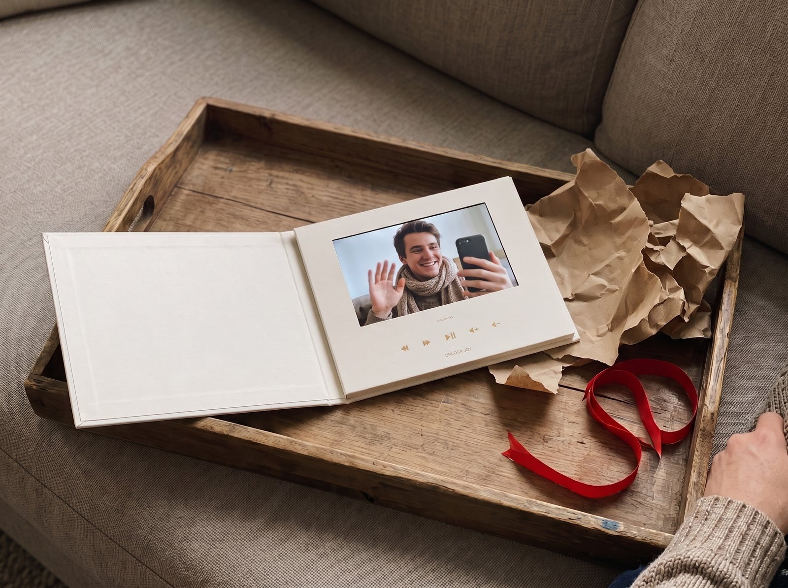 Hands sliding the Tribute Video Book out of its off-white slipcase