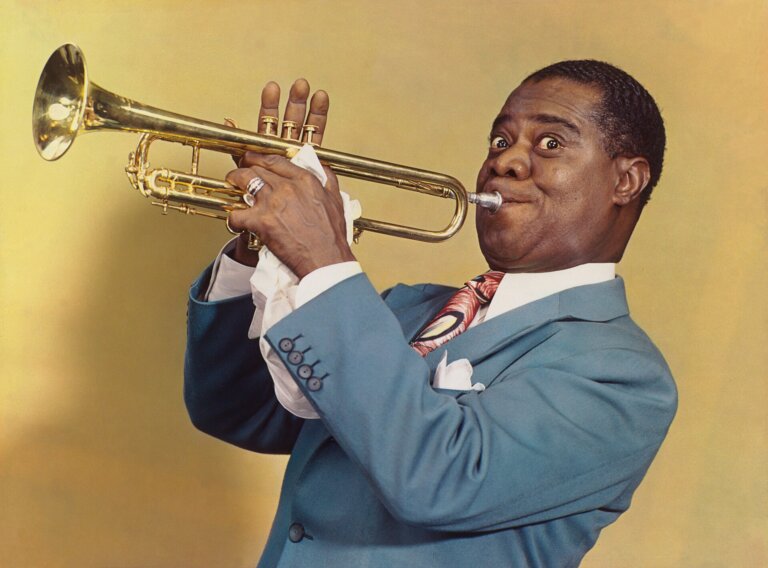 4 sierpnia 1901 roku w Nowym Orleanie, w dzielnicy zwanej „Back o’ Town”, przyszedł na świat człowiek, który zrewolucjonizował muzykę XX wieku. Louis Armstrong, znany także jako „Satchmo” lub „Pops”, był nie tylko wybitnym trębaczem i wokalistą jazzowym, ale też symboliczną postacią amerykańskiej kultury popularnej. Jego wpływ wykraczał daleko poza scenę muzyczną, zmienił sposób gry na trąbce, sposób śpiewania i sposób myślenia o muzyce improwizowanej.